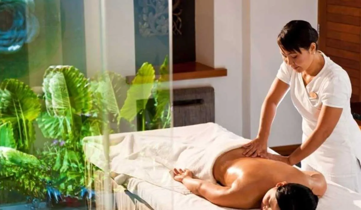 Therapist giving a guest a back massage in a spa treatment room