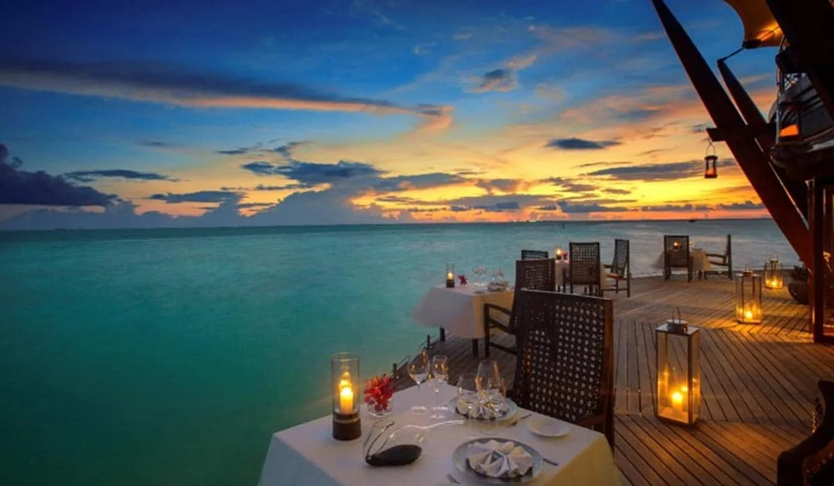 Candlelit dining deck over the sea at sunset