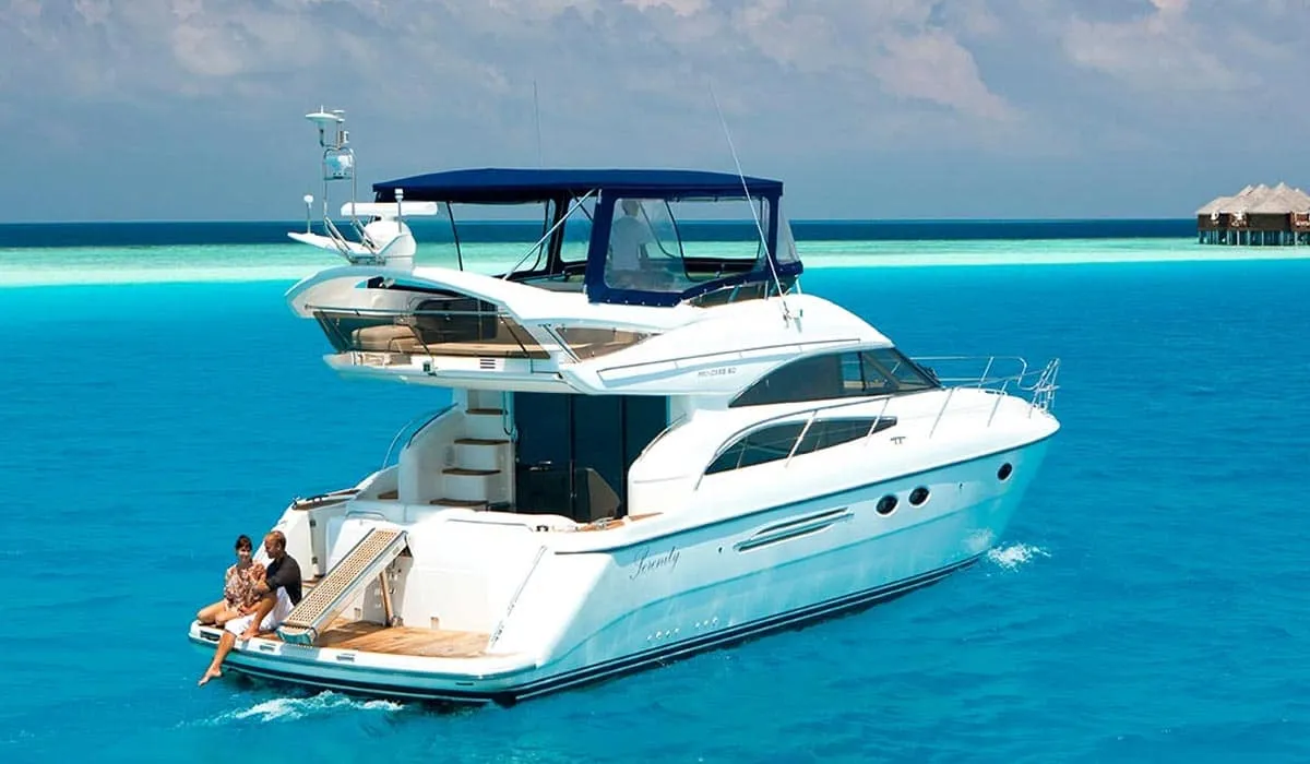 Couple relaxing on the back of a white yacht in turquoise water