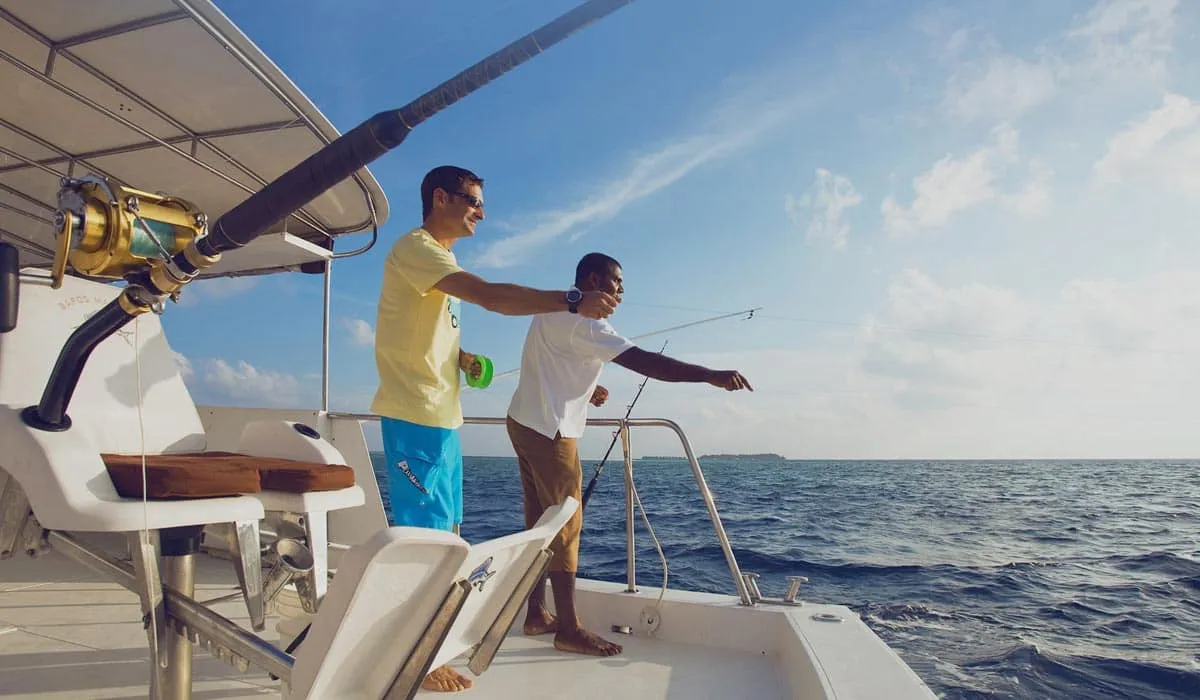 Two men fishing with rods from a yacht on the open sea