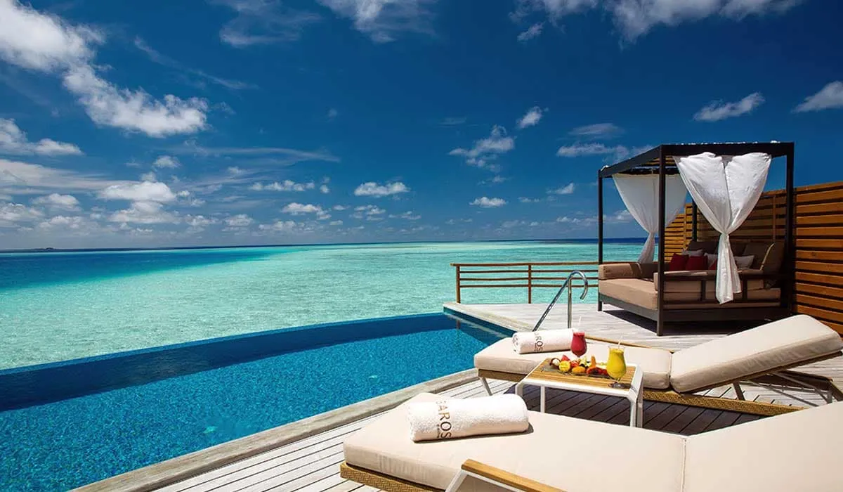 Water villa infinity pool and deck with loungers and a daybed over the sea