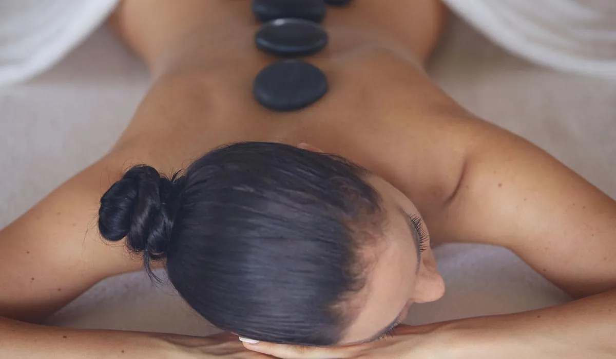 Hot stones placed along a woman's back during a spa massage
