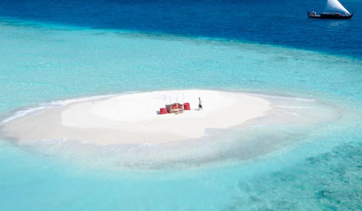 Aerial view of a picnic set up on a small sandbank in turquoise sea