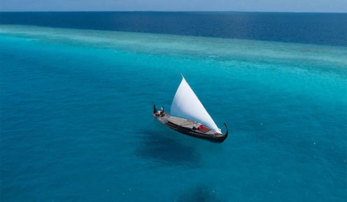 Traditional sailing boat gliding across the turquoise ocean, seen from above