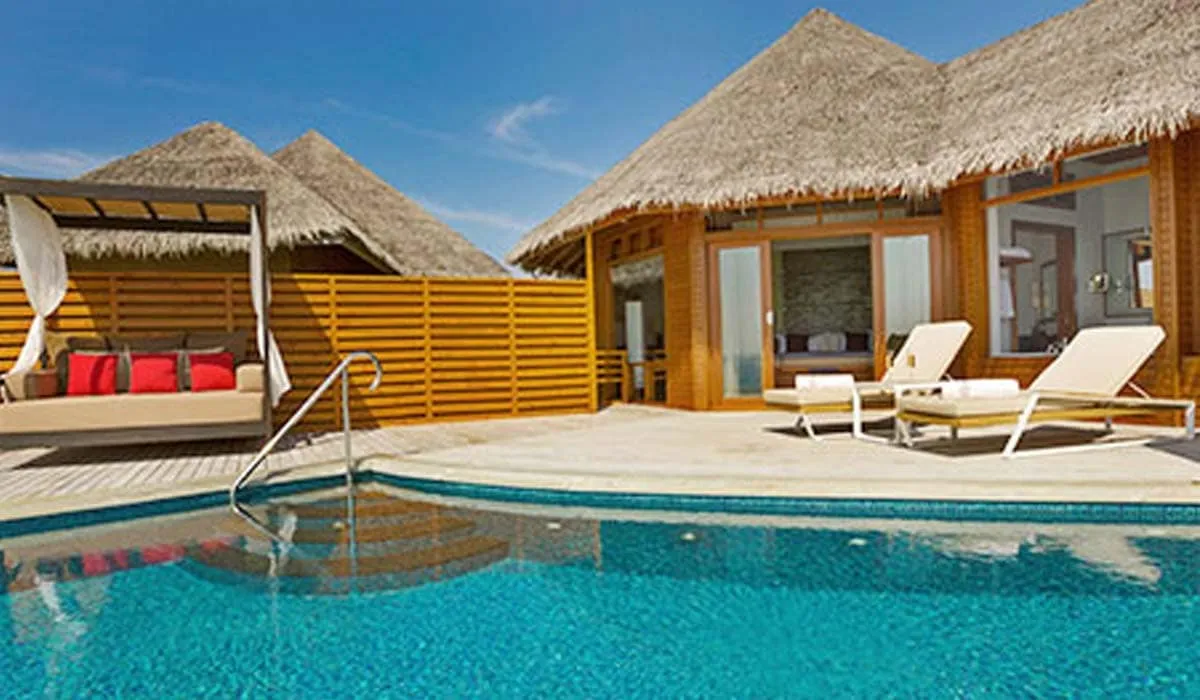 Thatched pool villa with sun loungers beside a private pool