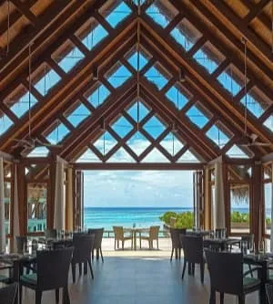 Restaurant with a high timber roof opening onto the sea