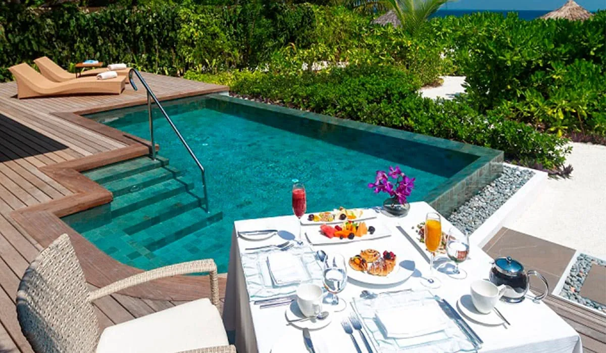 Breakfast laid on a table beside a private pool