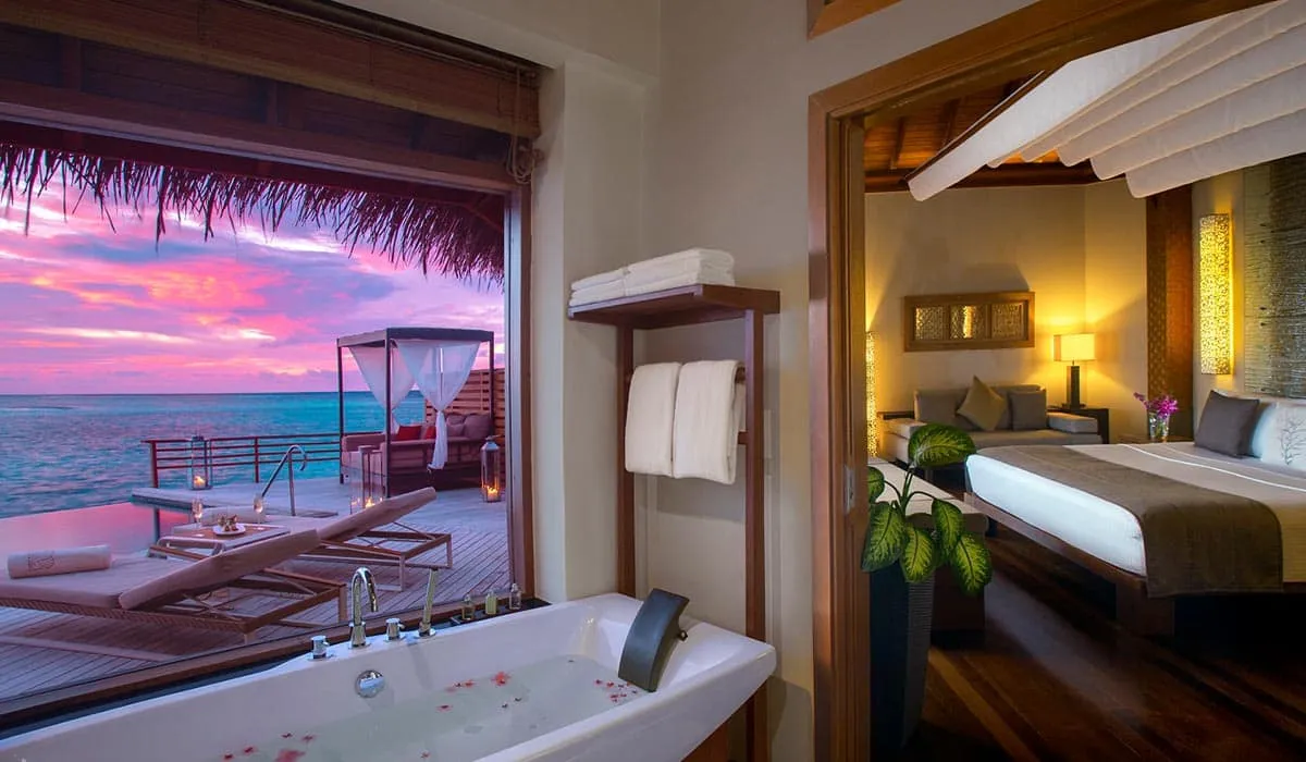 Villa bathtub with rose petals, opening onto the bedroom and a sunset sea view