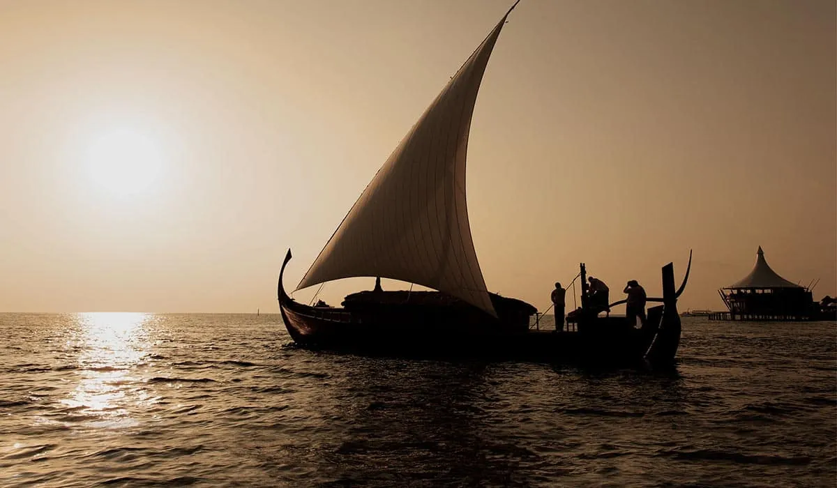 Traditional sailing boat silhouetted on the sea at sunset
