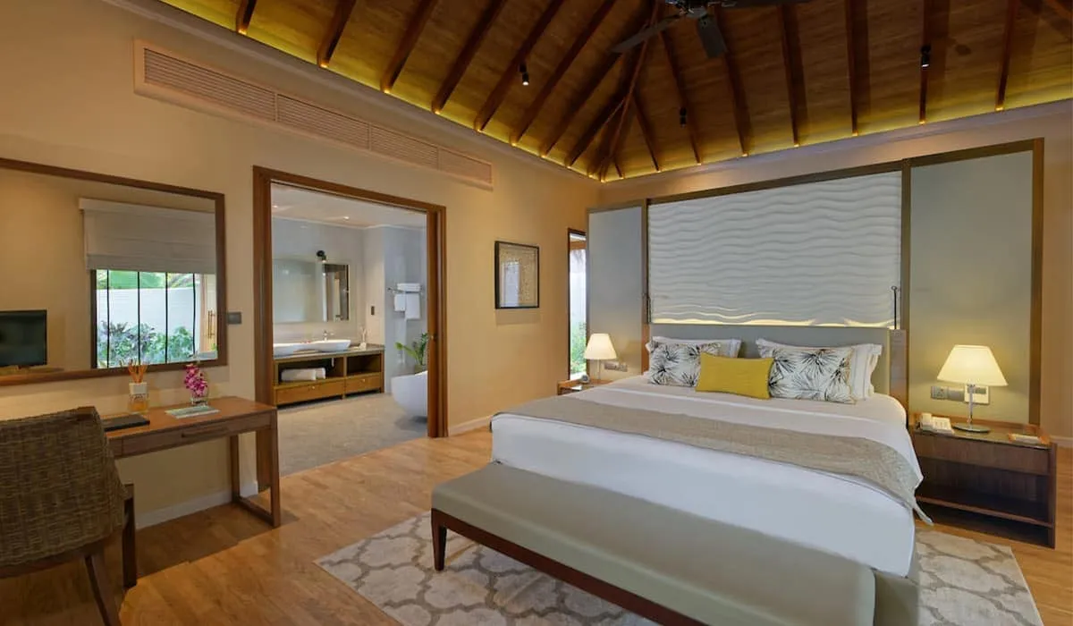 Residence bedroom with a large bed, timber ceiling and garden-view windows