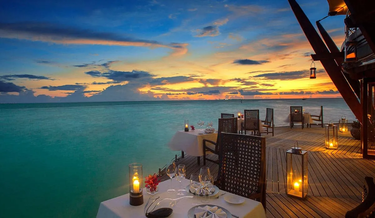 Candlelit tables on the Lighthouse restaurant deck overlooking the sea at sunset