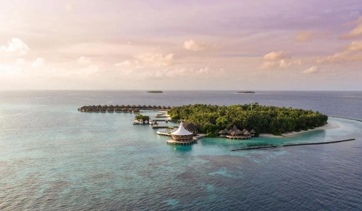 Aerial view of Baros island and its water villas at dusk