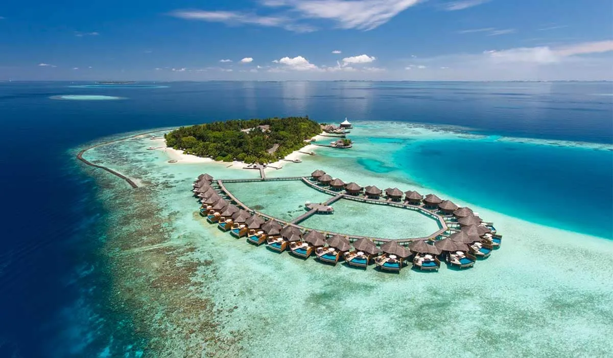 Aerial view of Baros island with its loop of water villas and reef