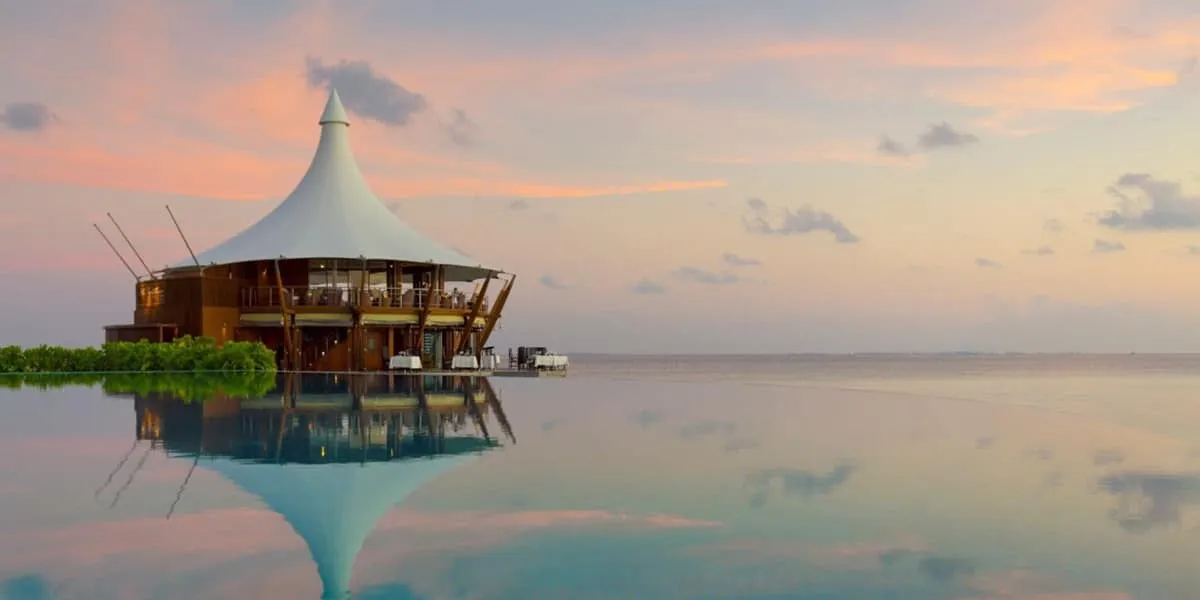 The Lighthouse Restaurant reflected in a calm sea at sunset
