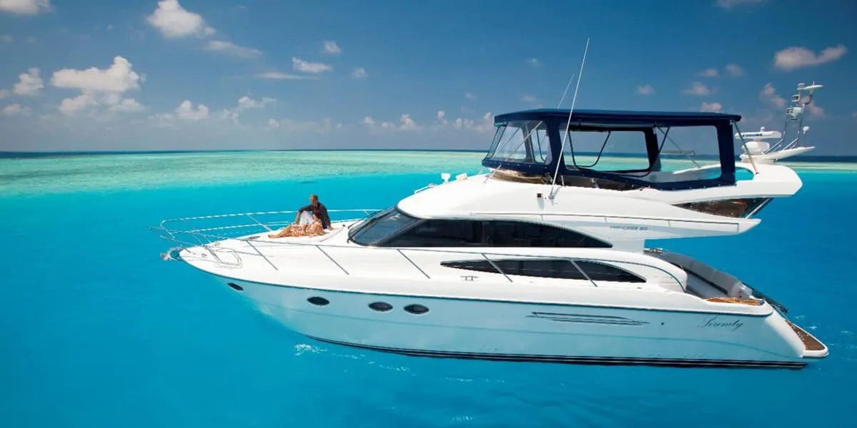 White motor yacht cruising across a turquoise lagoon