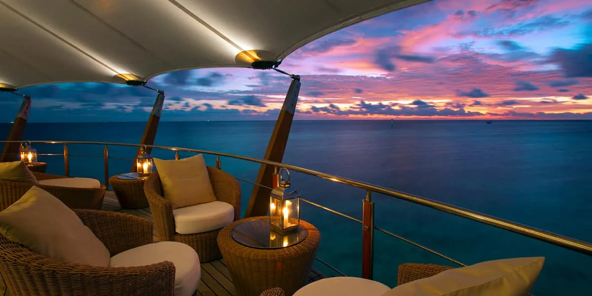 Lighthouse lounge seating with lanterns overlooking the sea at sunset