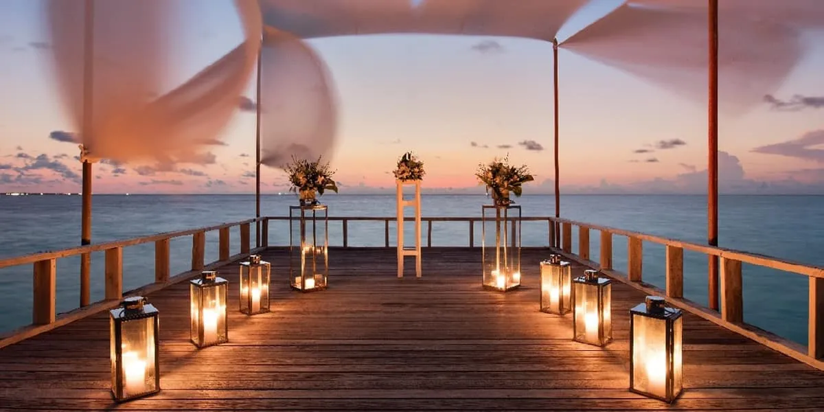 Piano deck lined with lanterns and flower stands at sunset
