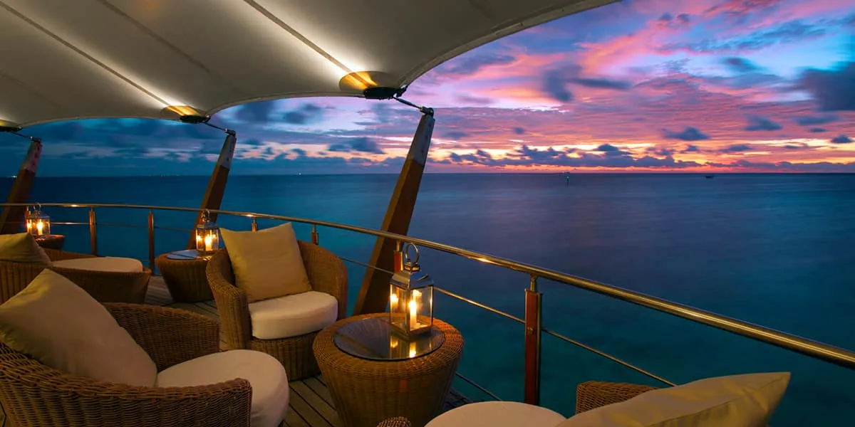 Lighthouse lounge seating with lanterns overlooking the sea at sunset