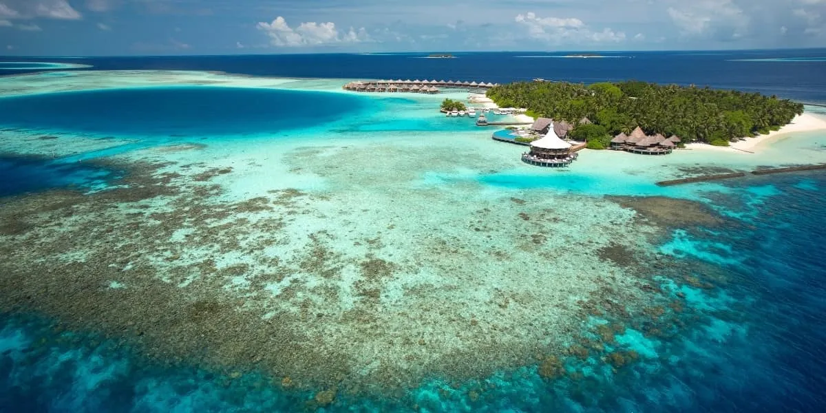 Aerial view of Baros island surrounded by a coral reef and lagoon