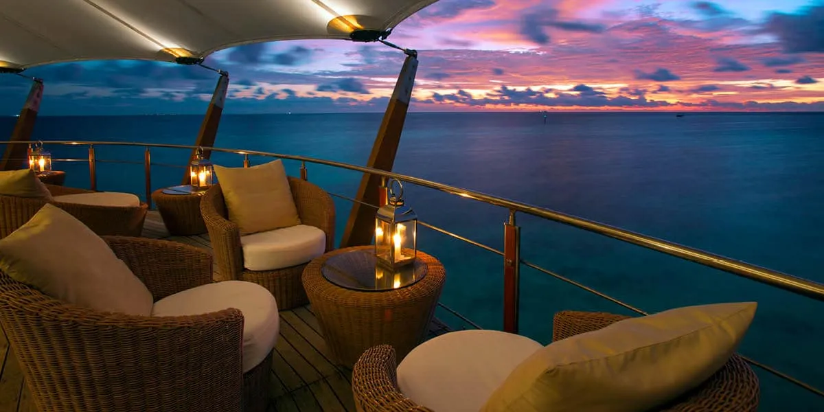 Lighthouse lounge seating with lanterns overlooking the sea at sunset