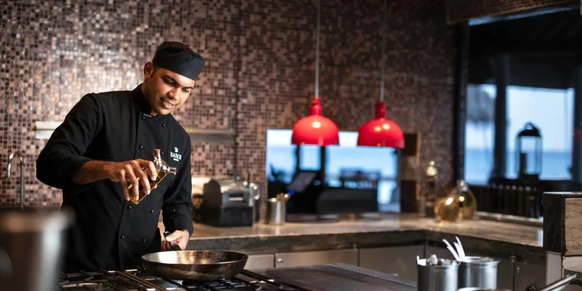 Chef cooking at the stove in an open kitchen