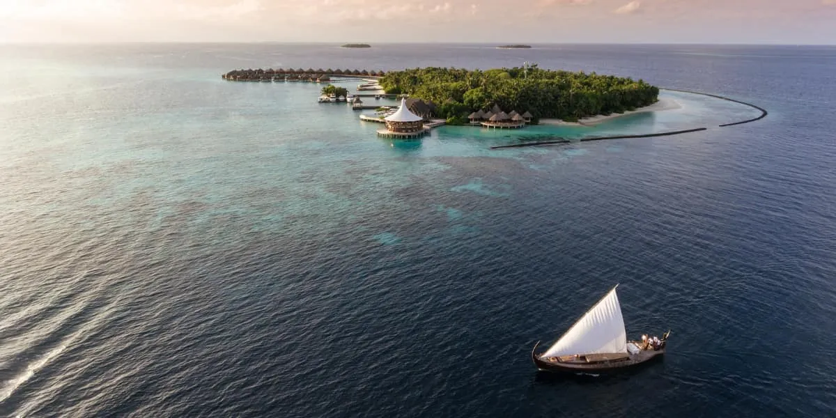 Aerial view of Baros island at dusk with a sailing dhoni