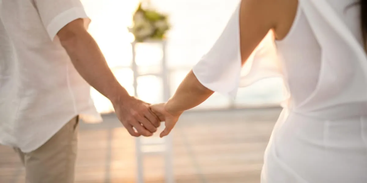 Close-up of a bride and groom holding hands