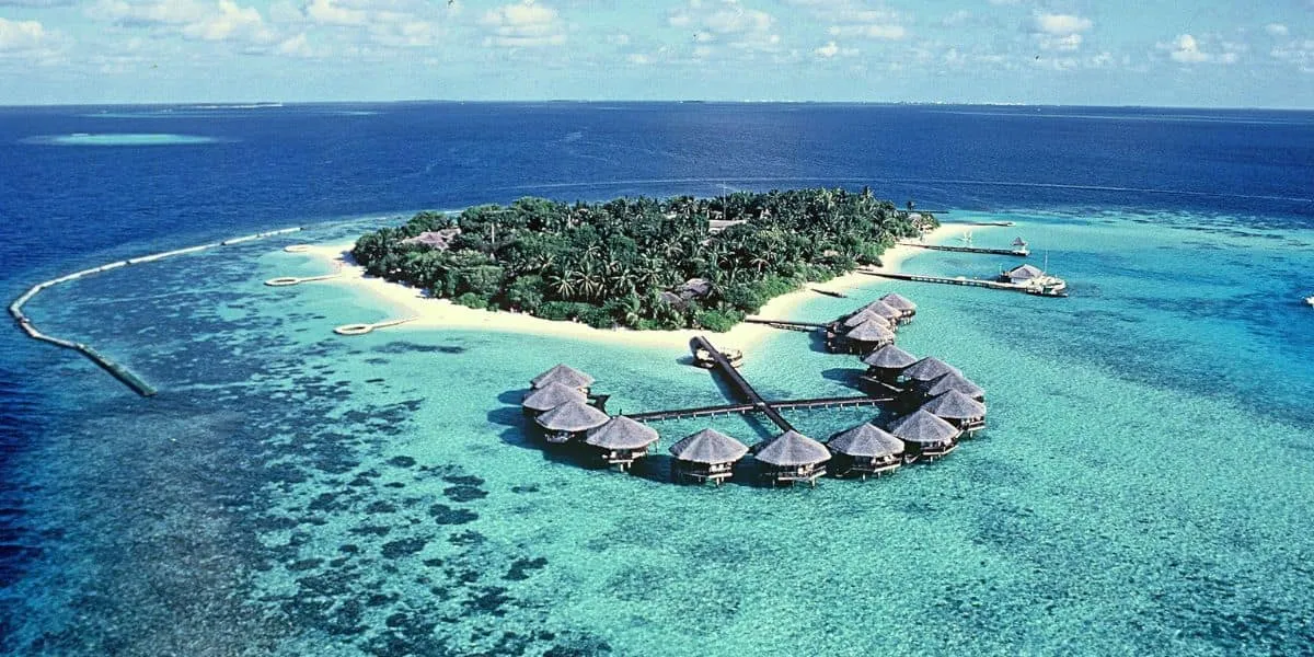 Aerial view of Baros island, its water villas and coral lagoon