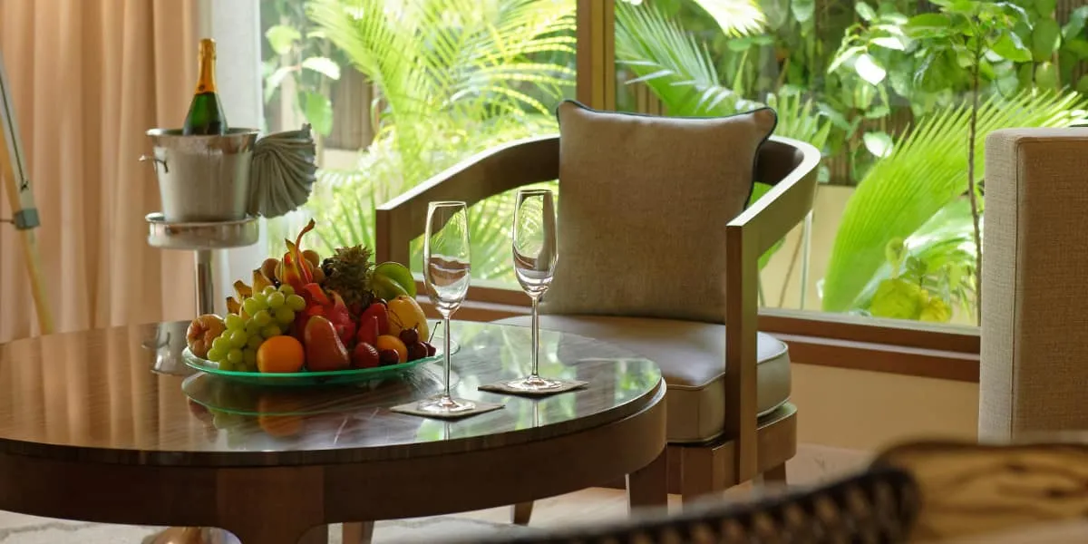 Fruit bowl, champagne on ice and glasses on a table in a villa sitting area