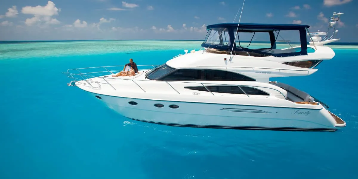 White motor yacht cruising on bright turquoise water