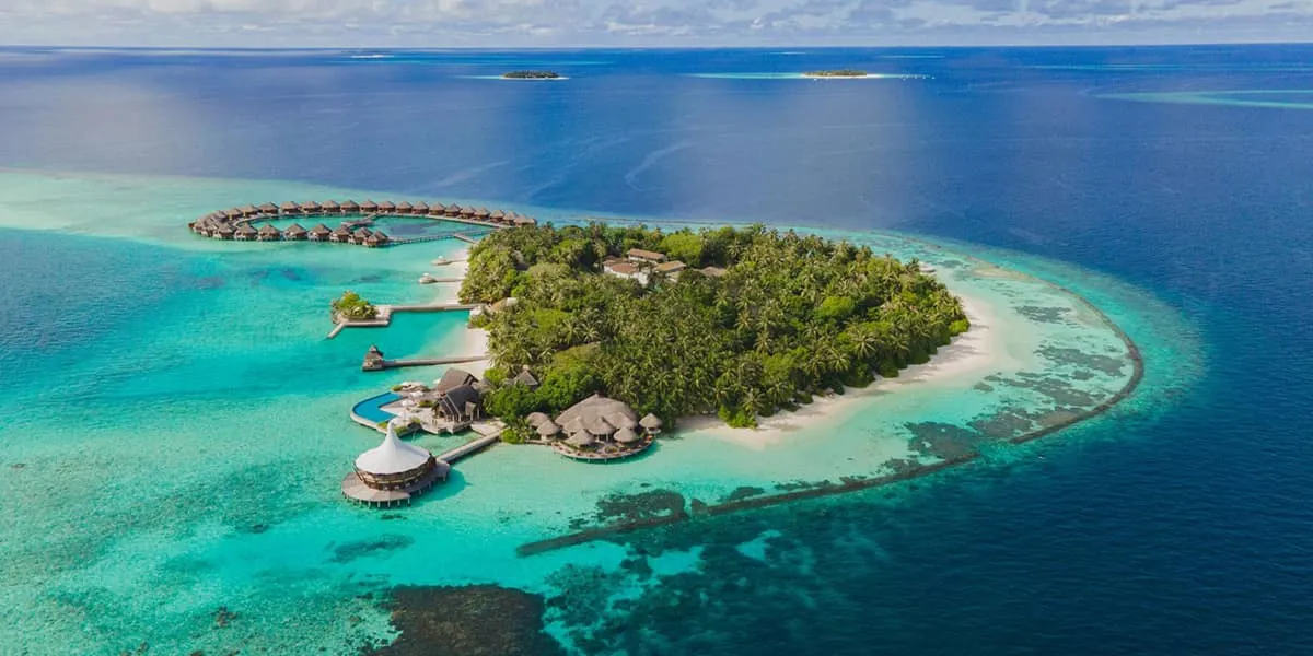 Aerial view of Baros island, its water villas and the surrounding reef