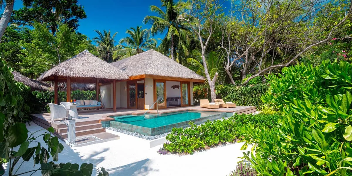 Thatched villa with a private pool and deck surrounded by tropical garden