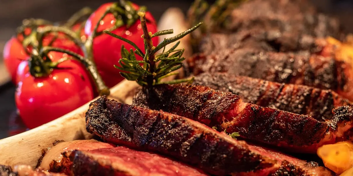 Close-up of sliced grilled steak with roasted cherry tomatoes