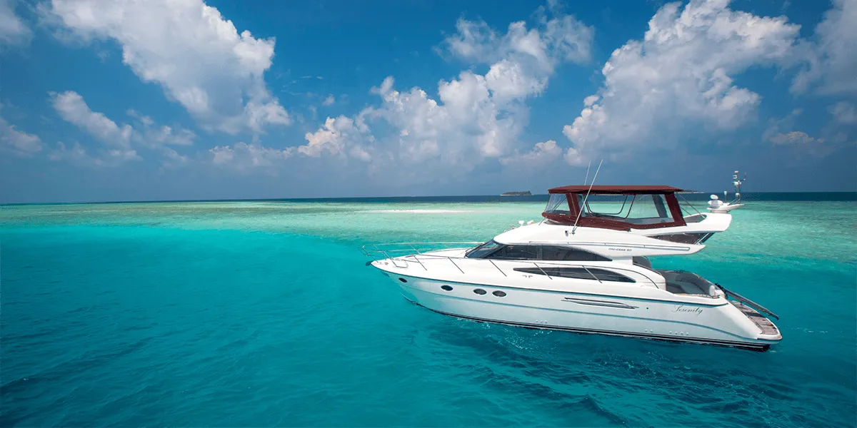 White motor yacht cruising on a turquoise lagoon under a blue sky