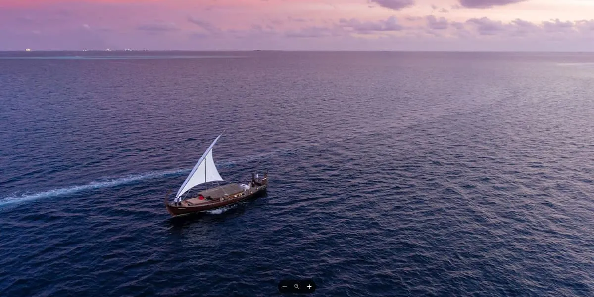 Aerial view of a traditional sailing dhoni on the open sea at dusk