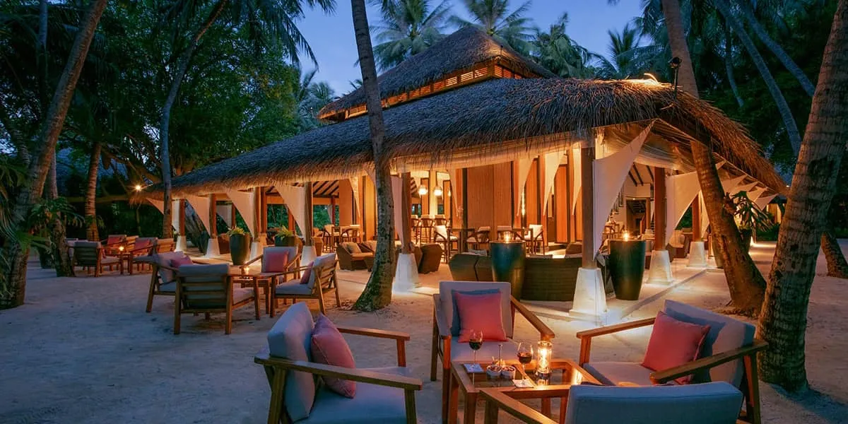 The exterior of the Palm Garden restaurant at dusk at Baros Maldives