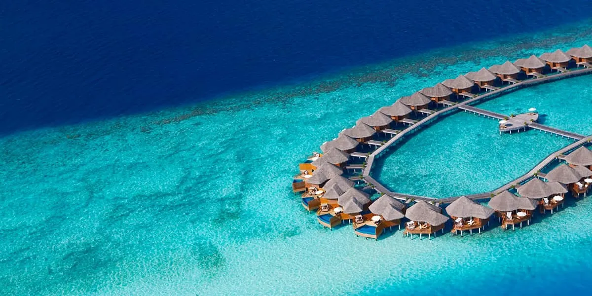 Aerial view of the curving row of water villas over a turquoise lagoon