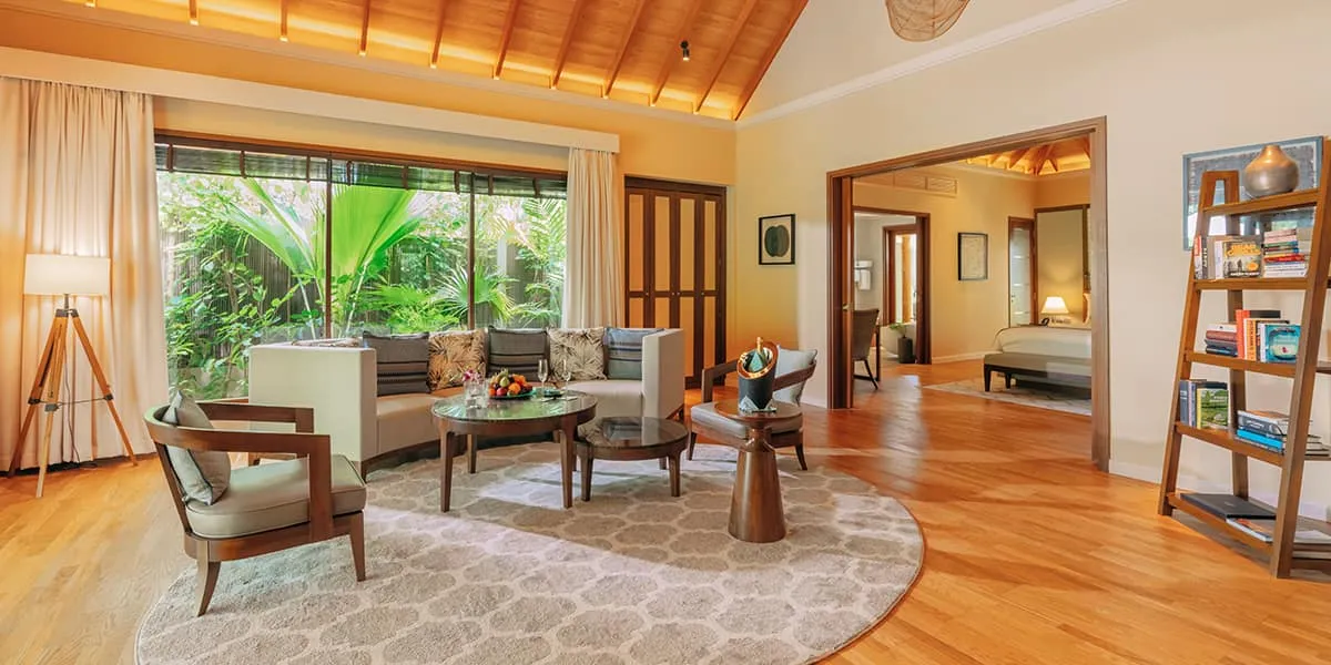 Bright living room with wooden floors, armchairs and garden views