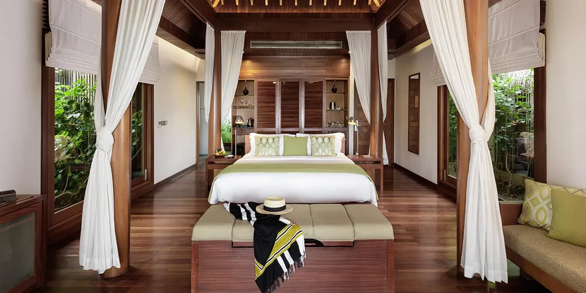 Villa bedroom with a four-poster bed framed by white curtains