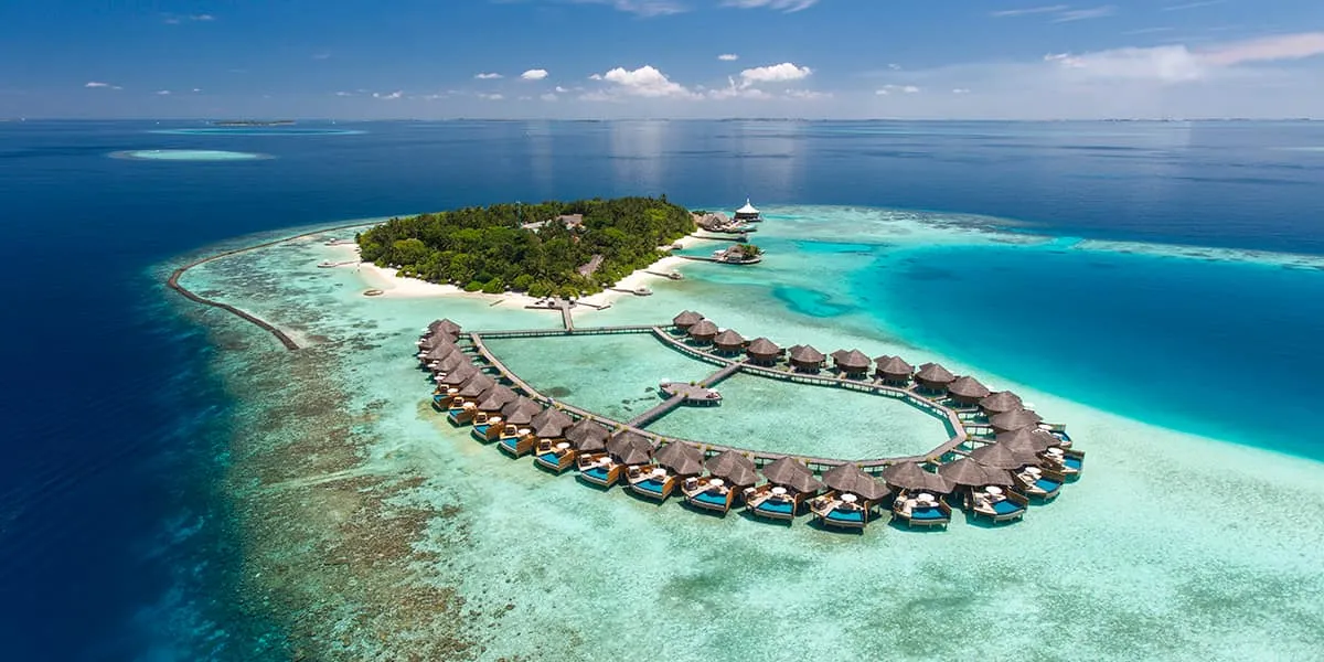 Aerial view of Baros island, its water villas and the surrounding reef