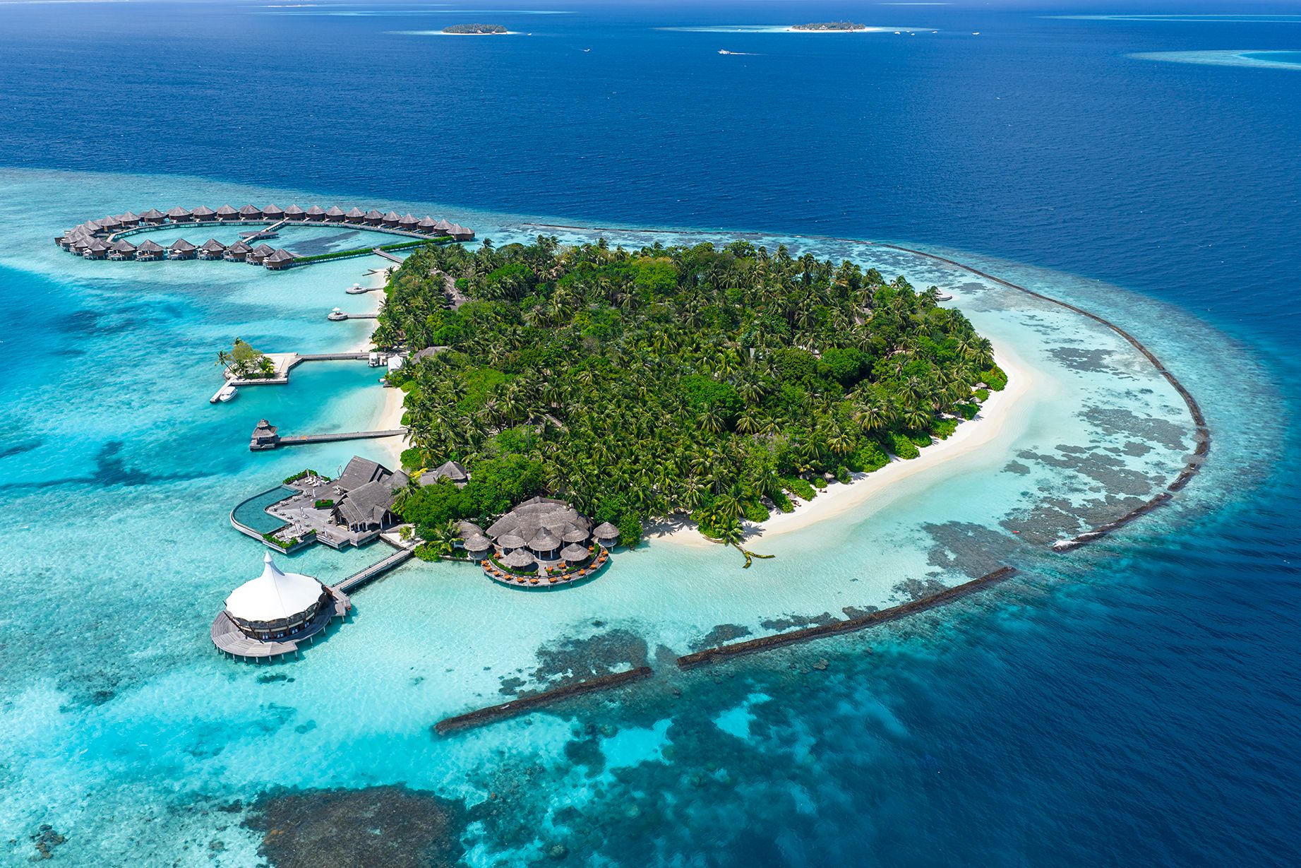 Aerial view of Baros island with its reef, beach and overwater villas