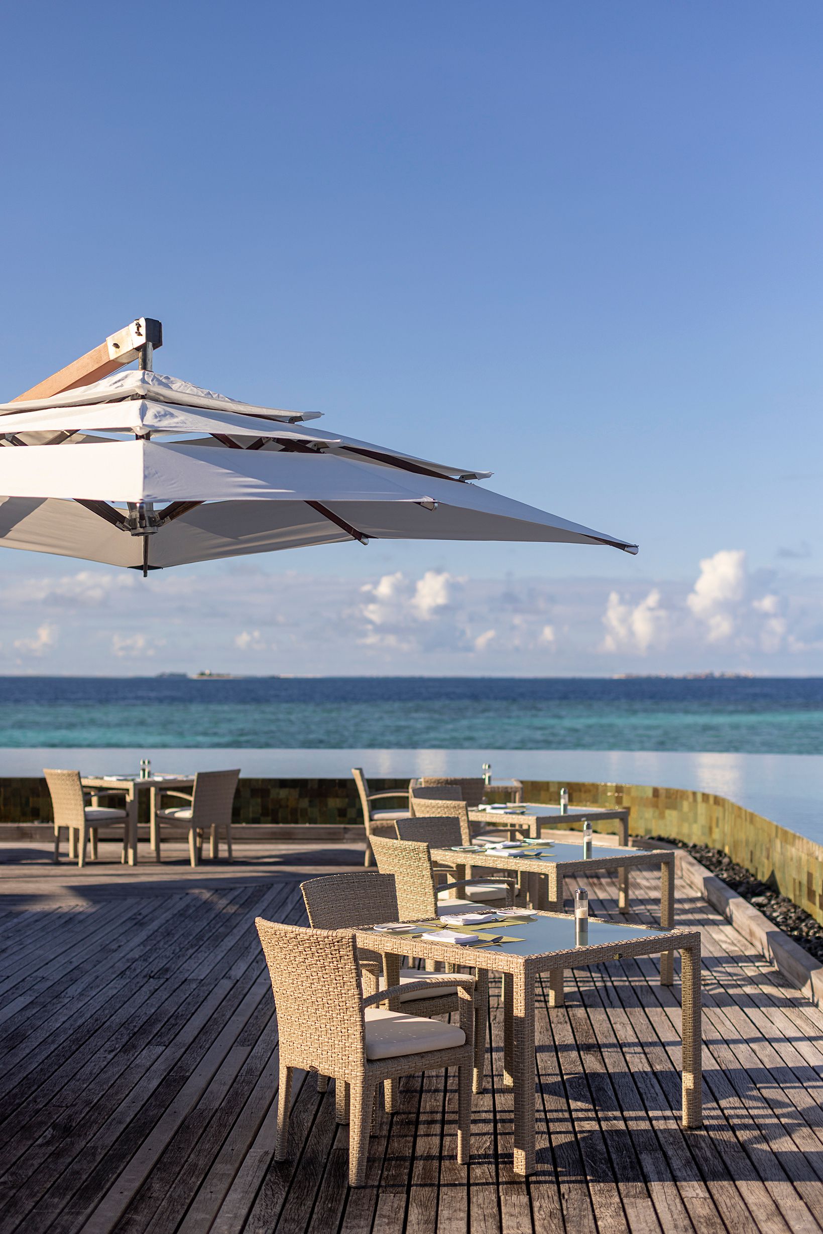 Lime restaurant deck tables under a parasol overlooking the lagoon