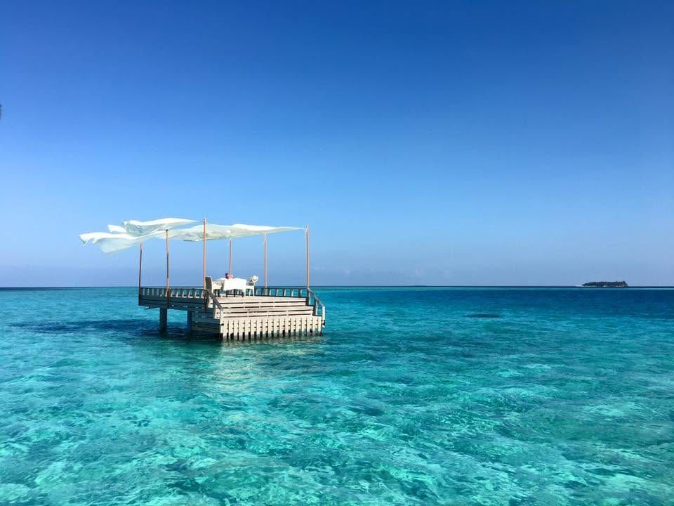 Canopied deck standing alone in shallow turquoise water