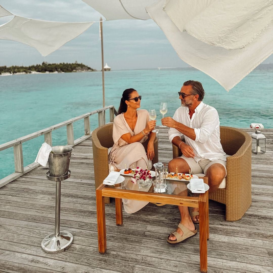 Couple toasting with champagne on an overwater deck