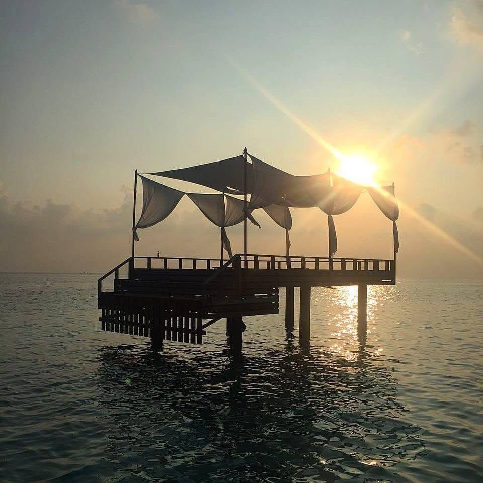 Silhouette of a canopied over-water deck at sunrise