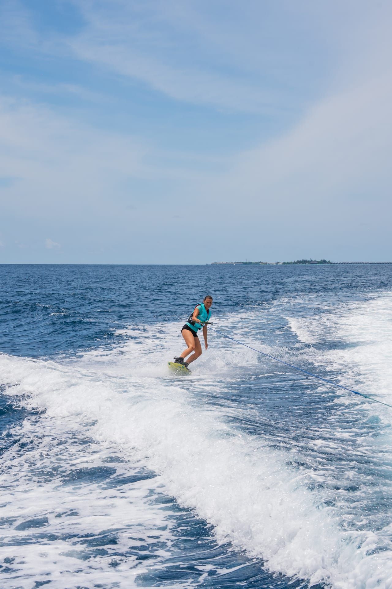 Wakeboarder riding the wake of a boat on open water