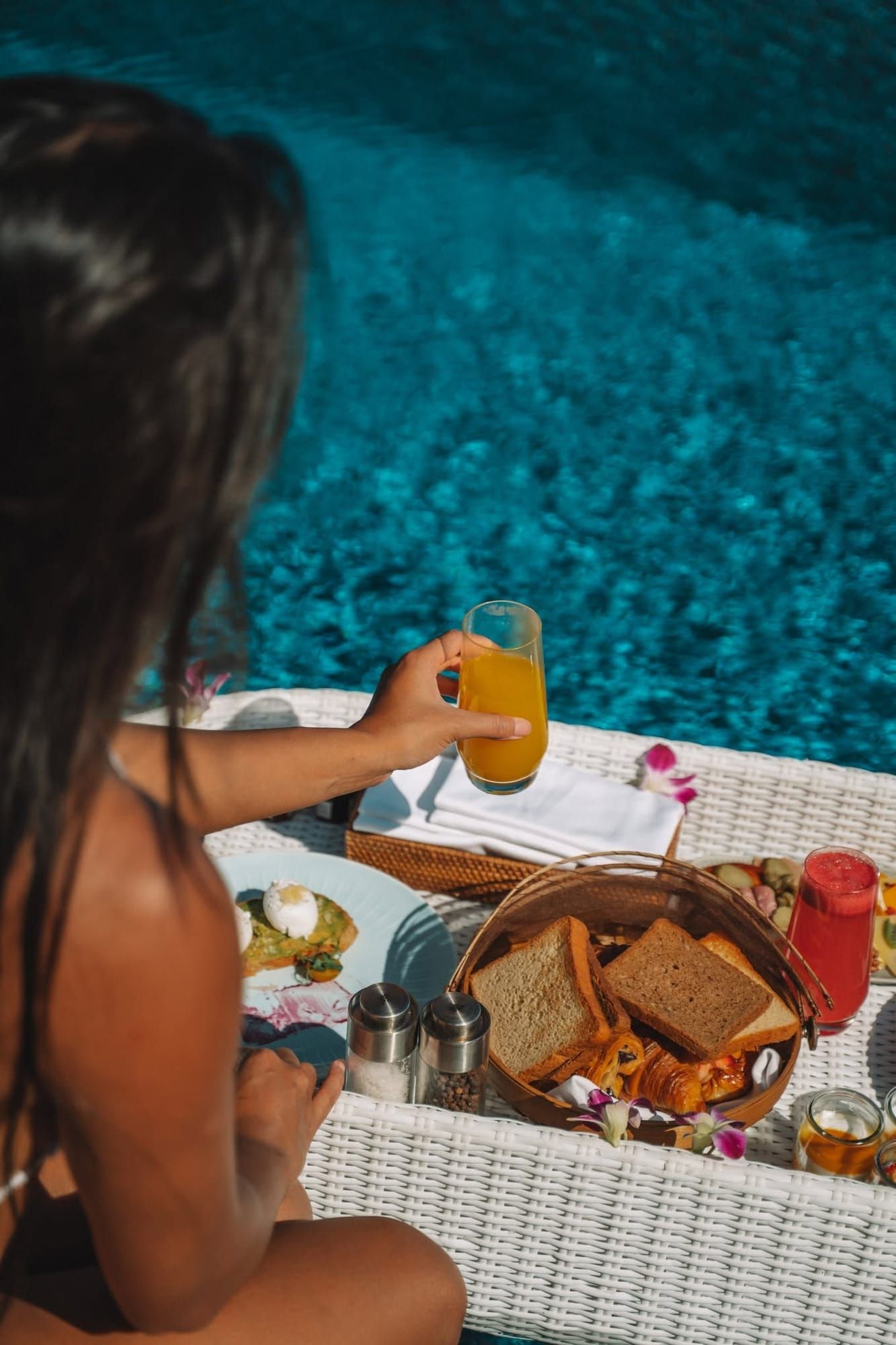 Woman enjoying a floating breakfast tray in a private pool