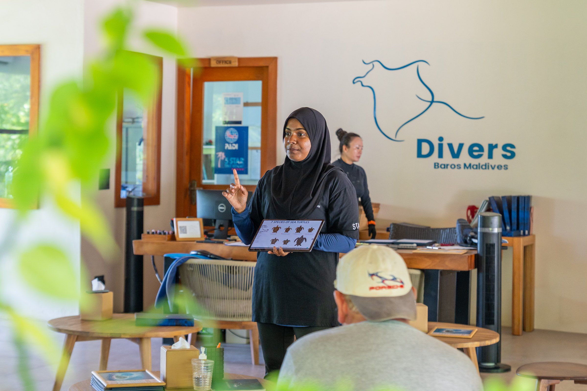 A Baros marine biologist giving a reef talk to guests at the dive centre
