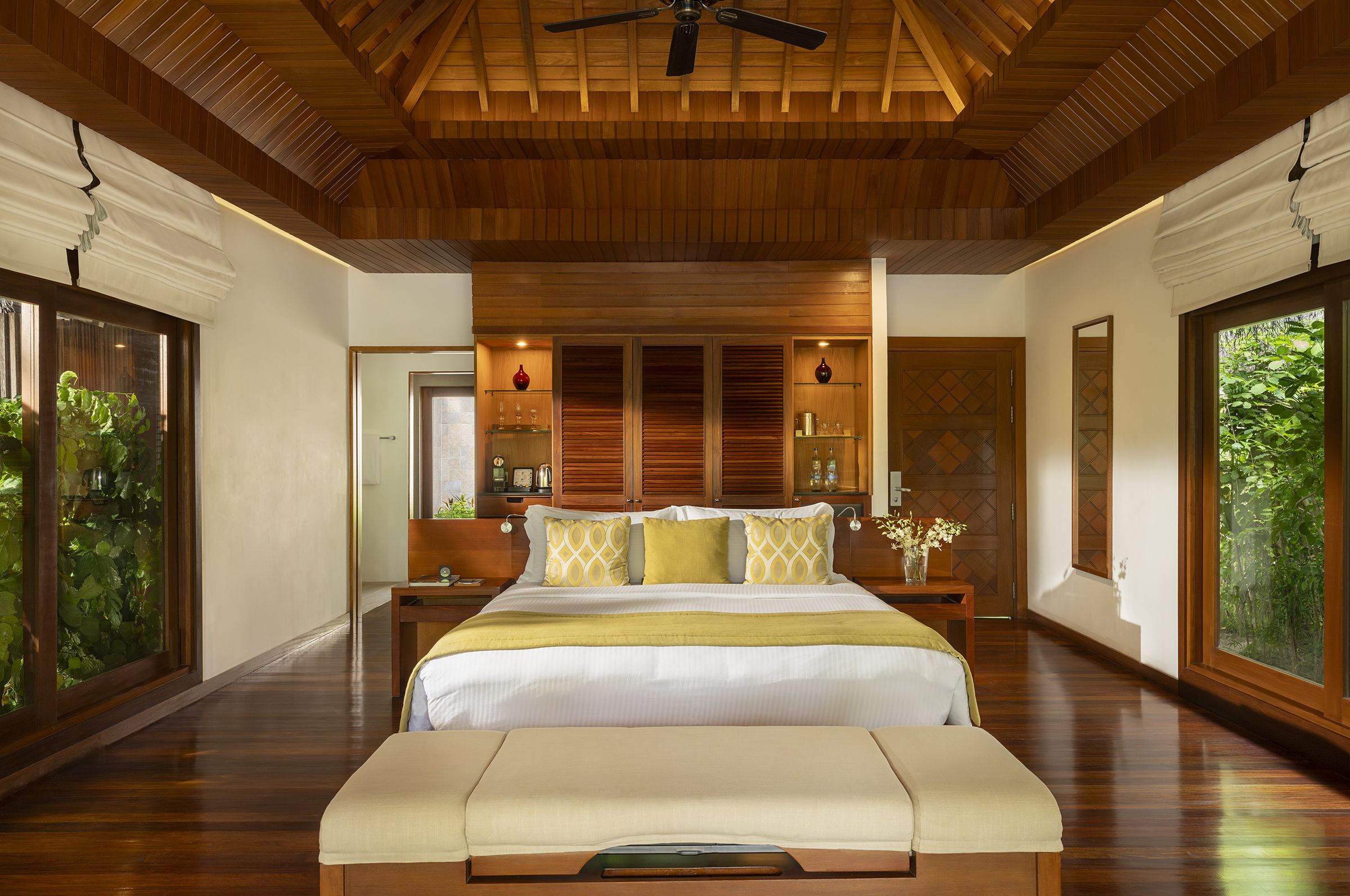 Bedroom of a Baros Villa: a king-size bed, timber floors and garden views
