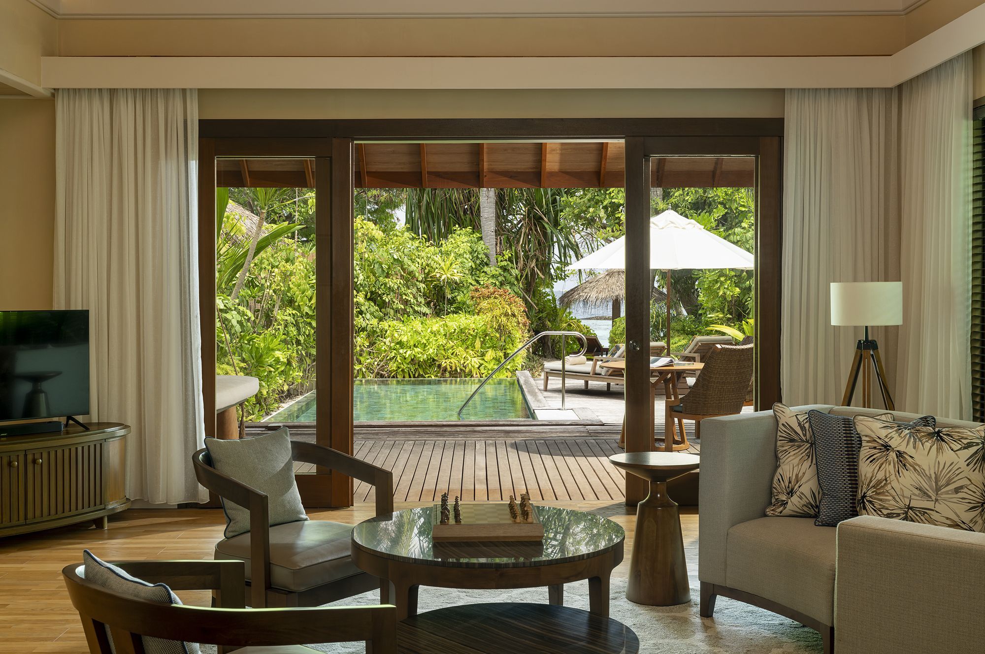 Living area of the Baros Residence opening onto the deck and private pool